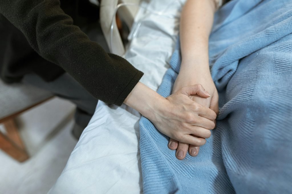 A comforting hand hold in a hospital, showcasing support and care.